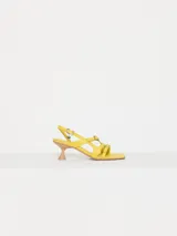 Sandalia amarilla de cuero vacuno con taco kitten heel color madera y tiras finas con hebillas metálicas.