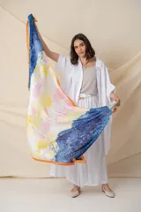 Pañuelo rectangular de seda con estampado abstracto en degrade de colores blanco, gris y naranja, con borde naranja.