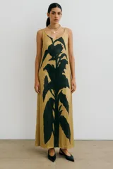 Vestido largo de seda con estampado floral abstracto en blanco sobre fondo negro, escote redondo y corte recto.