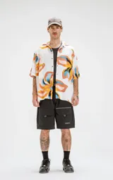 Camisa de manga corta de calce oversize, con estampado colorido en tonos cálidos y diseño de canesú en la espalda.