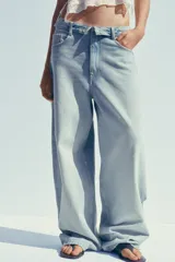 Pantalón de jean celeste de tiro alto con cintura doblada, cinco bolsillos, efecto lavado y roturas.