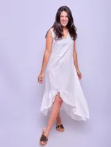 Vestido blanco sin mangas con volado en el ruedo, confeccionado en lino.