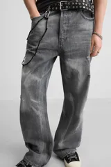 Pantalón de jean gris de corte flare, con cinco bolsillos, lavado con efecto de contraste en las piernas y bajo con acabado irregular.
