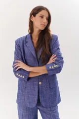 Blazer de lino color coral, con solapas de muesca, cierre con dos botones y bolsillos delanteros con solapa.