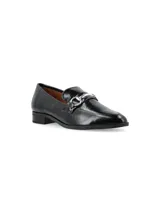 Zapato mocasín de cuero charol negro con detalle de hebilla plateada.