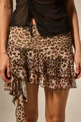 Minifalda de poliéster con estampado de leopardo, capas de volados y bajo asimétrico.