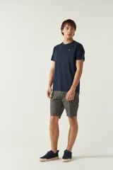 Bermuda cargo para hombre confeccionada en algodón y spandex, color verde oliva, con bolsillos laterales y traseros. Presenta logo en grifa metálica y pasa cintos.