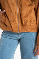 Chaqueta estilo bomber de gamuza color camel, con cuello alto, cierre frontal y calce oversize.