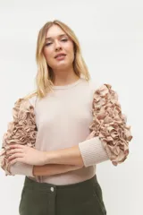 Remera negra de punto con mangas largas abullonadas con volantes.