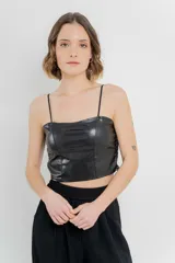 Top crop negro de cuero ecológico con tirantes finos y espalda de encaje floral con base nude.