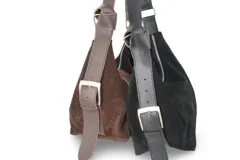 Cartera bandolera de gamuza color marrón topo, con correa ajustable de cuero marrón oscuro.