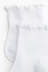 Pack de cinco pares de medias tobilleras blancas de punto acanalado, con borde superior elástico y ribete sobrehilado con volados.