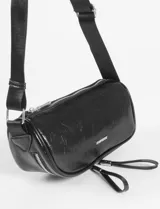 Riñonera cilíndrica de cuero vegano color borgoña, con dos compartimentos separados con cierres plateados. Posee una correa ajustable de tela negra y tiradores de cuero en las cremalleras.