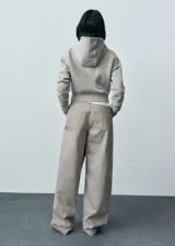 Pantalón de jean wideleg color gris claro, de tiro medio, con cinco bolsillos y cierre de cremallera.