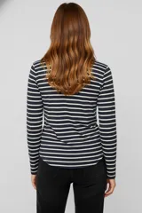 Remera de manga larga con cuello redondo y abertura frontal con botones. Presenta un patrón de rayas horizontales blancas y negras, y un pequeño bolsillo negro en el pecho.