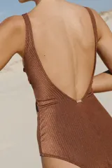 Traje de baño enterizo marrón acanalado con escote en V, breteles gruesos con argollas decorativas de resina color hueso y corte vedetina grande.