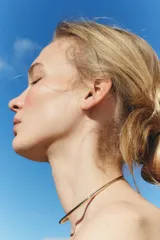 Gargantilla rígida dorada, tipo choker, con abertura en la parte delantera.