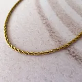 Collar de acero dorado con diseño torneado, ideal para combinar con otros collares.