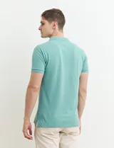 Chomba celeste con estampado de lunares blancos, cuello clásico y mangas cortas.