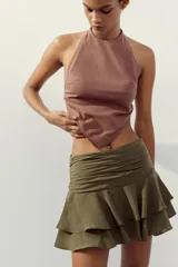 Falda pantalón corta color verde oliva, de tiro medio con detalle de pliegues en la cintura y volantes en el ruedo.