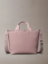 Mini cartera tote Calvin Klein color rosado, confeccionada en poliuretano con doble asa de mano y correa de hombro ajustable extraíble. Incluye cierre con botón a presión y bolsillo interior para tarjeta.