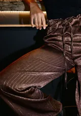 Pantalón negro de vestir con lurex plateado a rayas verticales, tiro alto y corte palazzo.