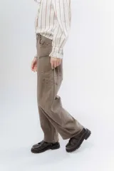 Jean wide leg color marrón, con corte recto y amplio, y costuras protagonistas que crean un diseño geométrico en las piernas.