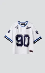 Camiseta estilo jersey de fútbol americano, color blanco, con cuello en V ribeteado en azul. Presenta el número "90" grande en el frente en azul marino con borde blanco. Tiene bordados en el pecho como "Lx." y "Ravers", y números pequeños en las mangas. Los puños tienen franjas azules y negras.