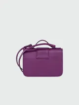 Bandolera Longchamp modelo Box-Trot XS, color fucsia, con correa fina ajustable y logo circular metálico en el frente.
