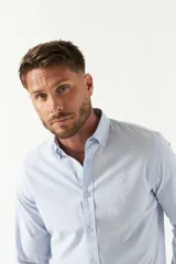 Camisa de hombre a rayas verticales azules y blancas, corte slim fit, con logo bordado en el pecho.