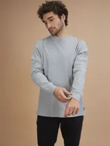 Remera de manga larga gris, confeccionada en tejido waffle.