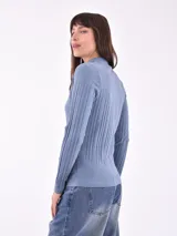 Polera rosa de tejido canalé, con cuello alto y mangas largas.