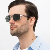 Lentes de sol INVU con montura metálica plateada de forma rectangular y lentes polarizadas verdes. Patillas negras.