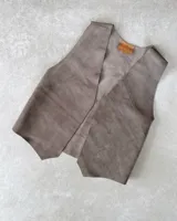 Chaleco marrón de gamuza con corte clásico y costuras decorativas.
