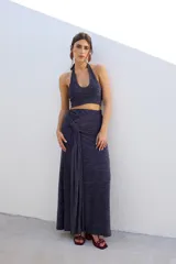 Top corto azul con brillos, escote halter y espalda descubierta.