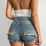 Short de jean celeste con lavado ácido, tiro alto, corte ajustado, bolsillos traseros con bordados y terminaciones desflecadas.