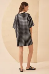 Vestido corto a rayas horizontales blancas y negras, con cuello redondo y mangas cortas. Presenta un estampado frontal con la palabra "L'AMOUR" en rojo y una flor roja. Tiene un tajo lateral en el ruedo.