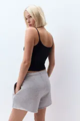 Top corto negro de punto elástico con breteles finos y escote redondo amplio.