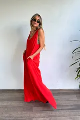 Vestido largo rojo vibrante, de corte holgado y sin mangas, con escote en V pronunciado y bolsillos laterales.