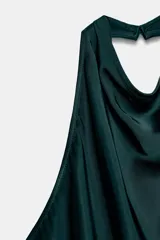 Top negro satinado con cuello halter, manga sisa y bajo asimétrico. Cierre en la espalda.