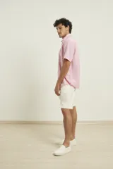 Camisa sport de manga corta color verde oliva, línea premium, con cuello clásico, cierre frontal con botones de coco y bolsillo de parche en el pecho. Confeccionada en lino y algodón.