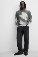 Jersey de punto gris con efecto tie-dye blanco, de corte relaxed fit, cuello redondo y mangas largas.
