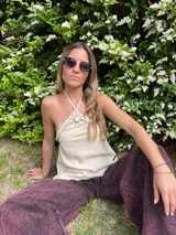 Musculosa color crema de lino y alpaca, con breteles finos que se atan al cuello y detalle de adorno de nácar en el centro del escote.