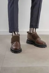 Botinetas negras de cuero con suela track y ajuste con velcro.