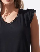Remera negra de modal con escote en V y aplique de puntilla en mangas y escote. Detalle fruncido en hombros.