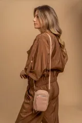 Bandolera compacta de símil cuero color rojo, con correa regulable y desmontable. Posee apertura superior, bolsillo frontal con cierre y bolsillo trasero abierto.