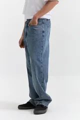 Pantalón de jean azul de corte amplio y tiro medio, con bolsillos delanteros y traseros.