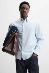 Camisa azul marino de algodón con textura jacquard, corte relaxed fit, cuello solapa, manga larga con puños abotonados y cierre frontal con botones.