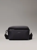 Cartera negra confeccionada con poliéster reciclado, cuenta con dos correas desmontables y cierre de cremallera en la parte superior.