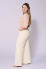 Pantalón de jean color crudo, corte wide leg, tiro alto y confeccionado en tela con lycra.